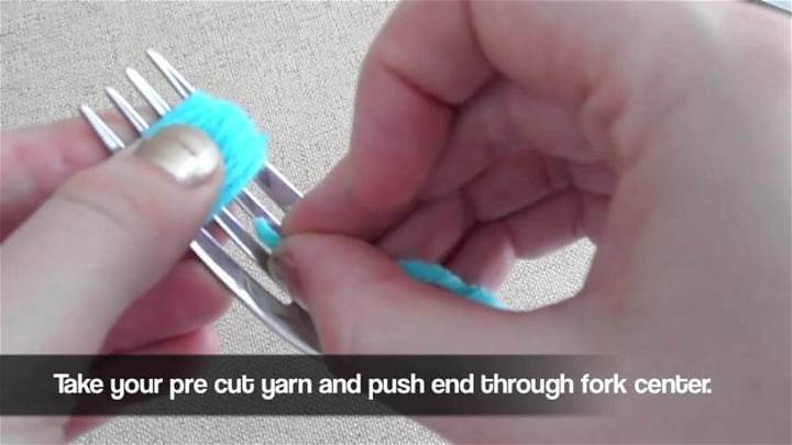 pushing the yarn through center of the fork