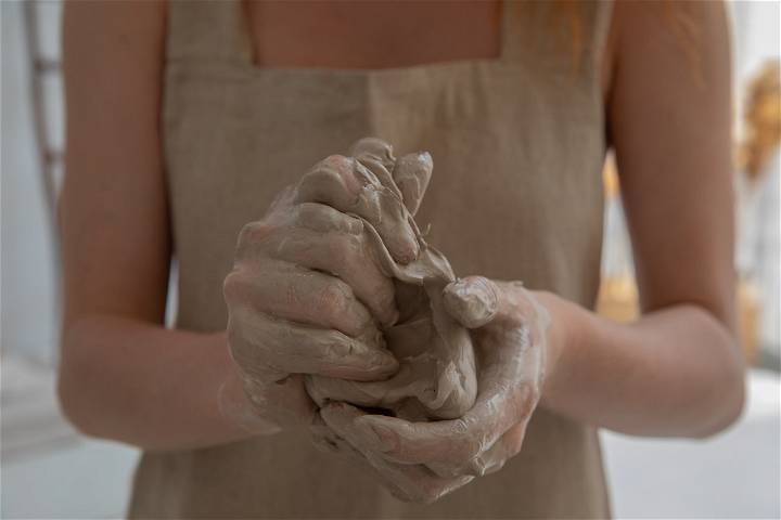A woman kneading clay