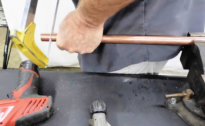 cutting copper pipe with a hacksaw